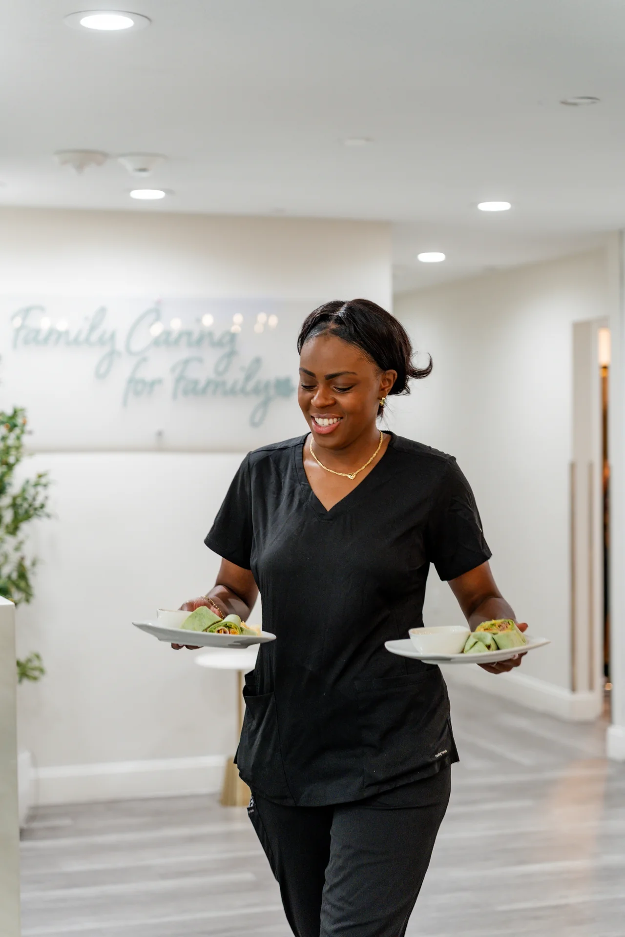 A caregiver carrying plates to the table