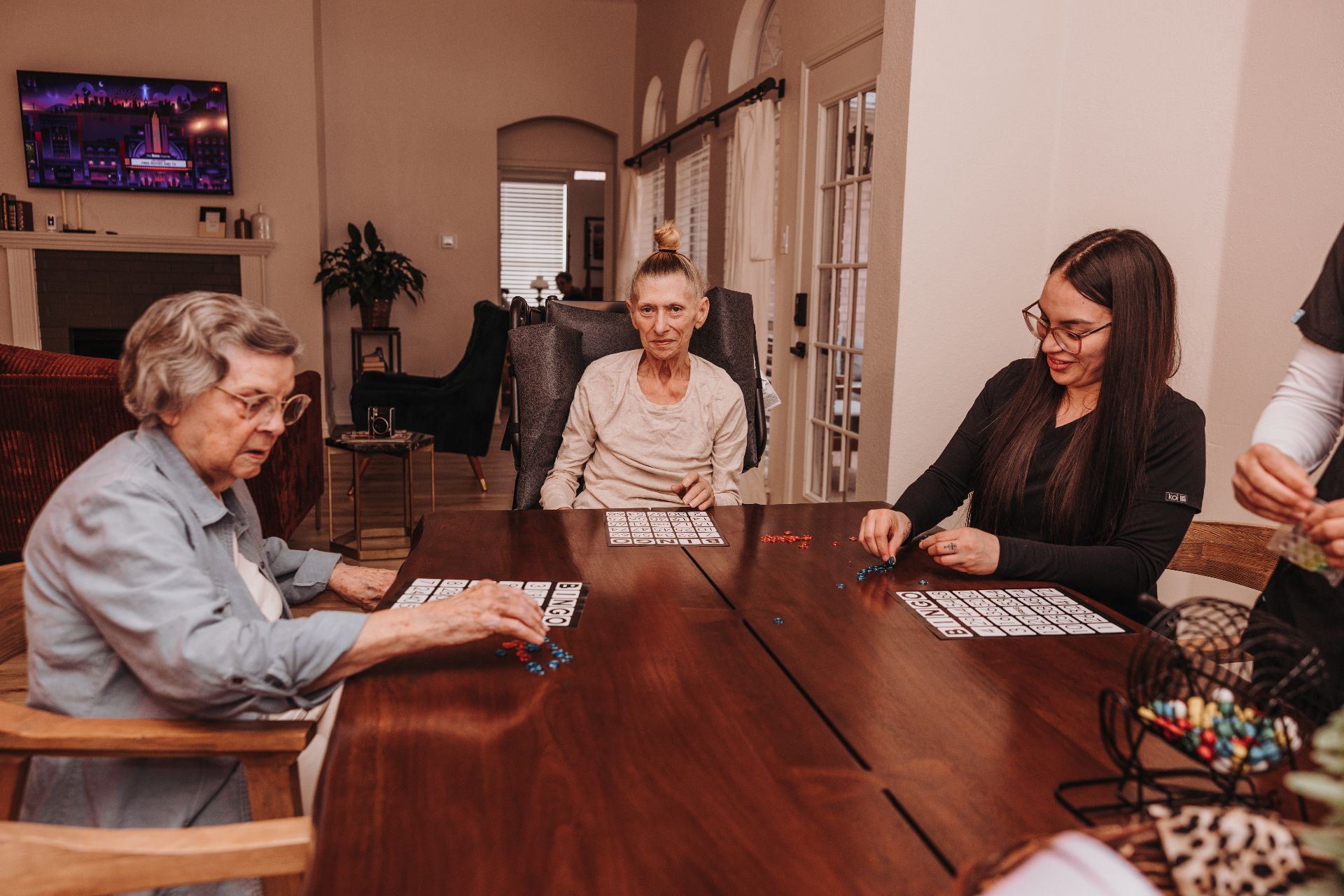 A caregiver and residents playing bingo at the table